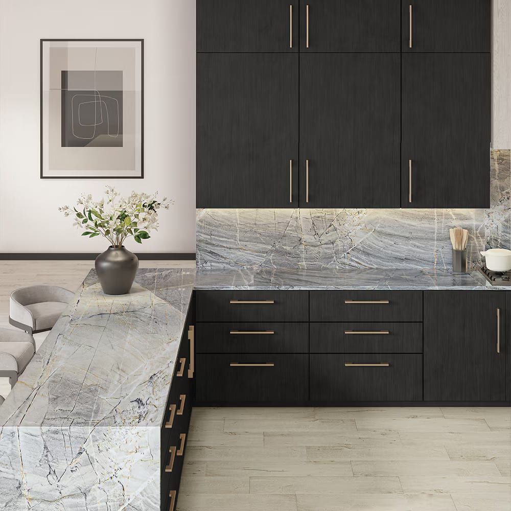 Modern kitchen with dark cabinetry and a dramatic blue-grey natural stone waterfall island with soft flowing veining from Daltile Stone Center.