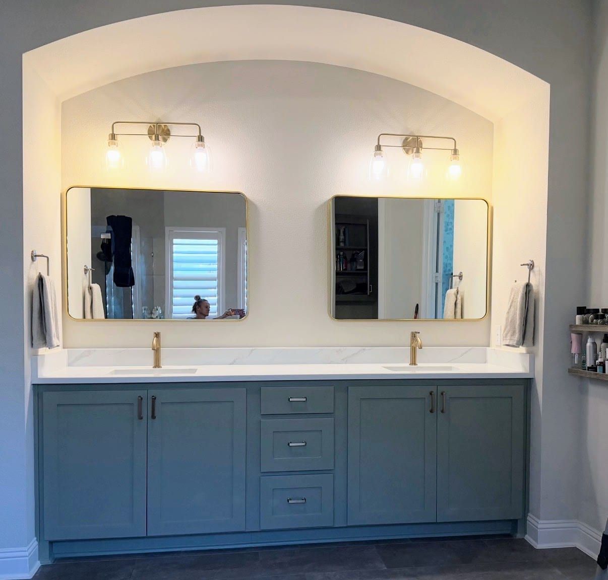 Double bathroom vanity with a white quartz countertop with subtle gray veining, dual under-mount sinks, and gold fixtures.