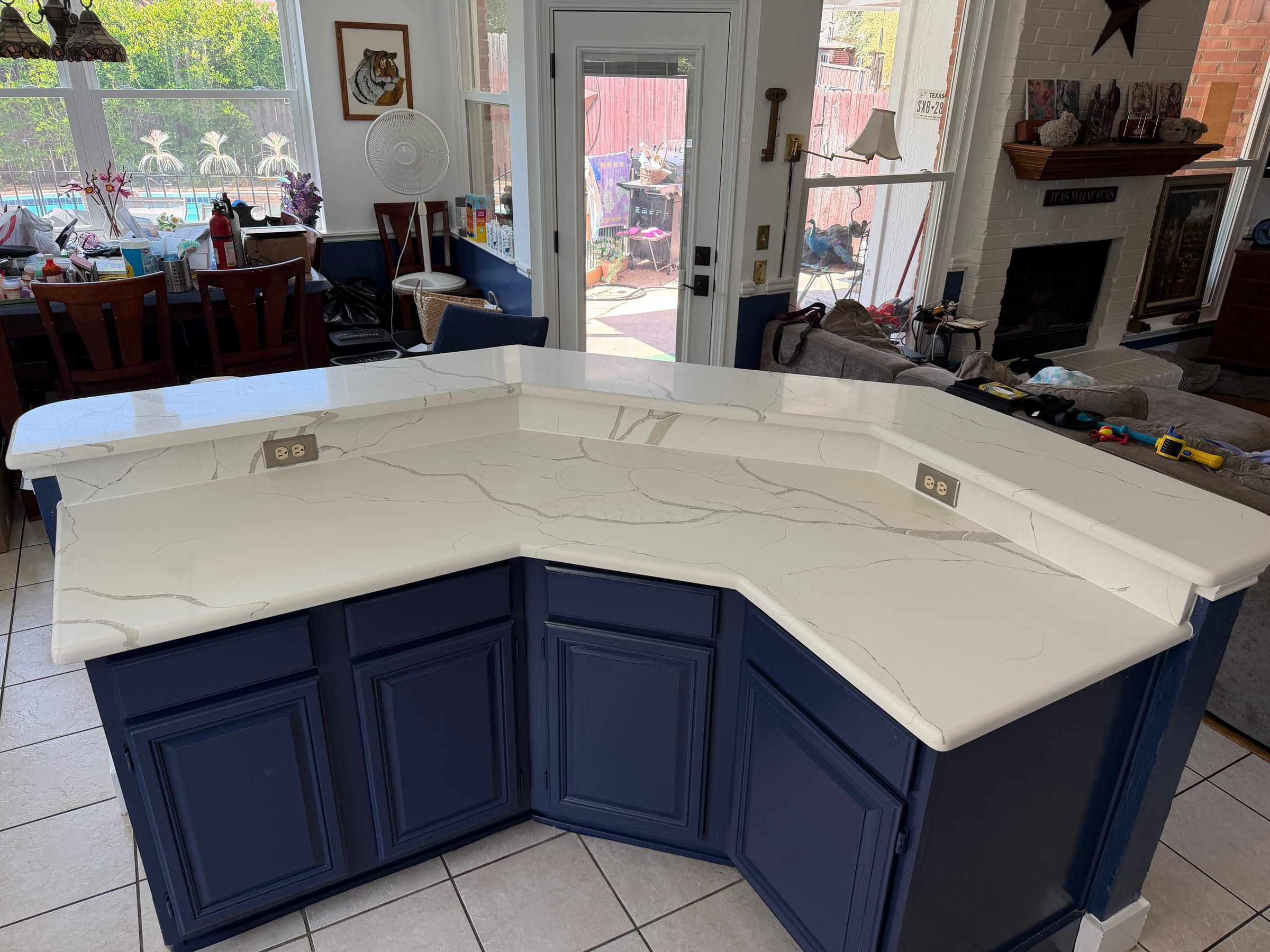 Two-tier kitchen island featuring white quartz countertops with subtle grey veining and a multi-level breakfast bar.